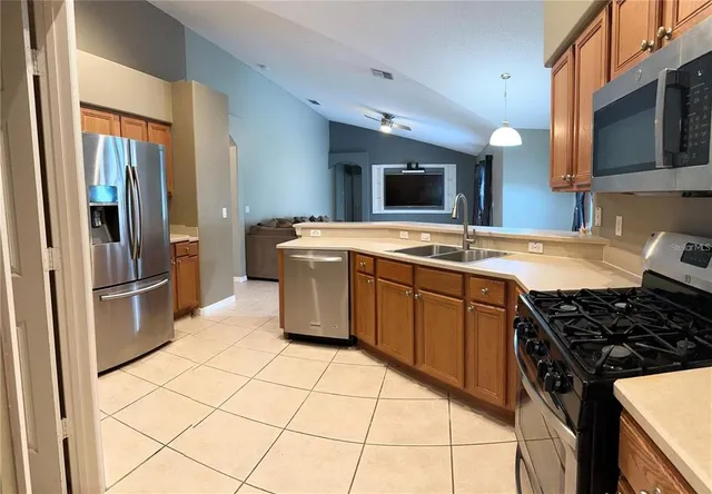 a kitchen with stainless steel appliances granite countertop a stove a sink dishwasher and a refrigerator