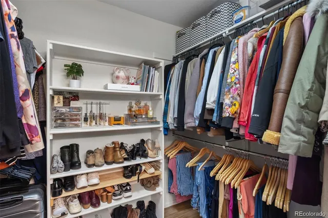a view of walk in closet with clothes and shoes