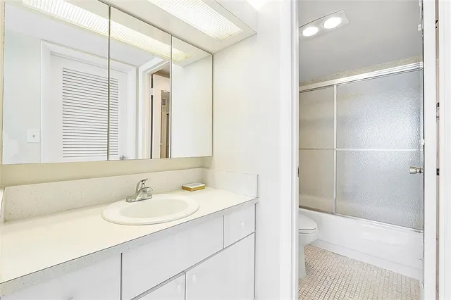 a bathroom with a double vanity sink mirror and shower
