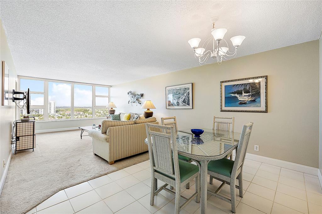 1620 South Ocean Boulevard, Unit 15J Lauderdale-by-the-Sea, FL 33062 - Photo 6 of 28 a dining room with wooden floor and a chandelier
