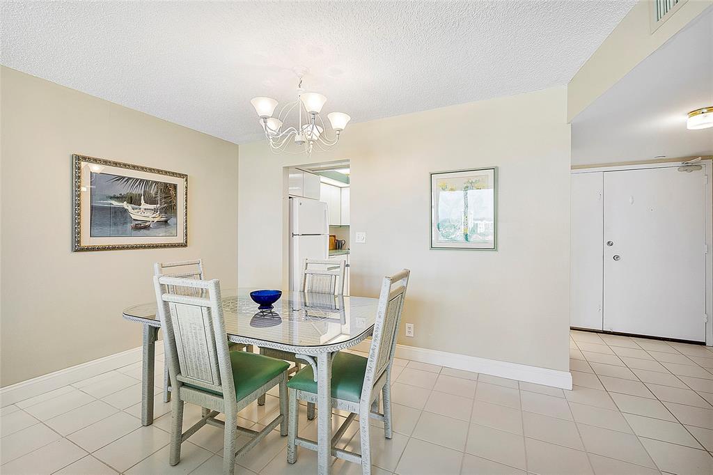 1620 South Ocean Boulevard, Unit 15J Lauderdale-by-the-Sea, FL 33062 - Photo 7 of 28 a view of a dining room with furniture and chandelier