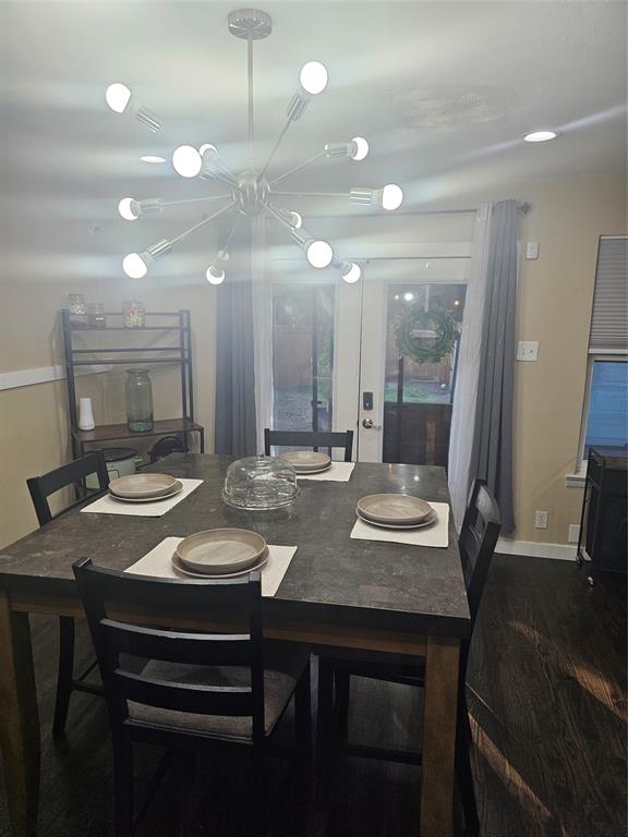 9911 Ferguson Road Dallas, TX 75228 - Photo 6 of 18 Dining space featuring dark wood-style flooring and a chandelier