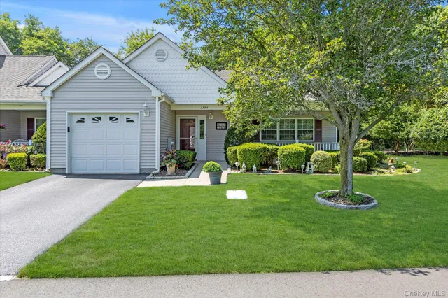 a front view of a house with a yard and green space