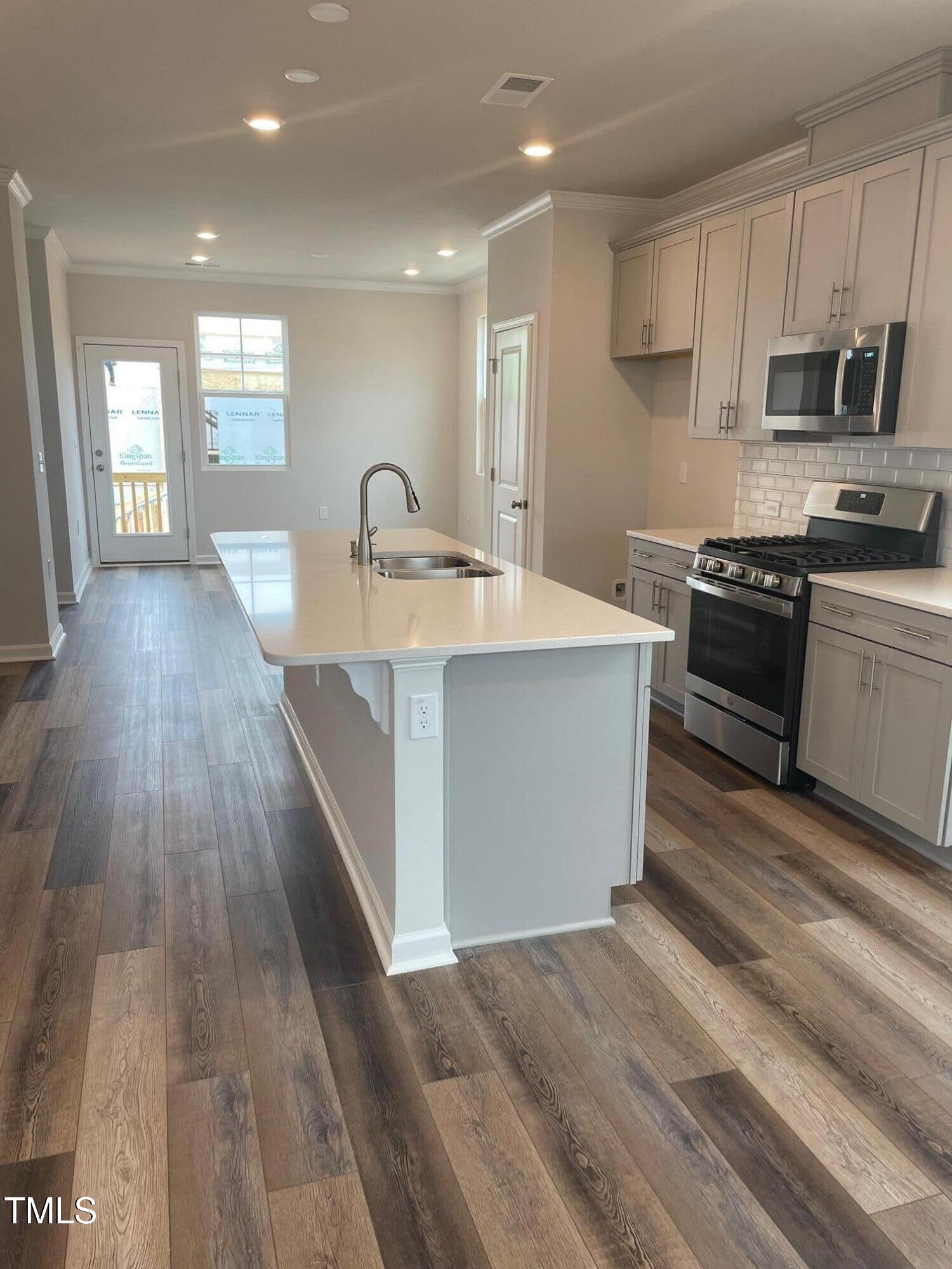 364 Devon Clfs Drive Wake Forest, NC 27587 - Photo 5 of 30 a large kitchen with stainless steel appliances a large counter top a stove a sink dishwasher and a refrigerator with wooden floor