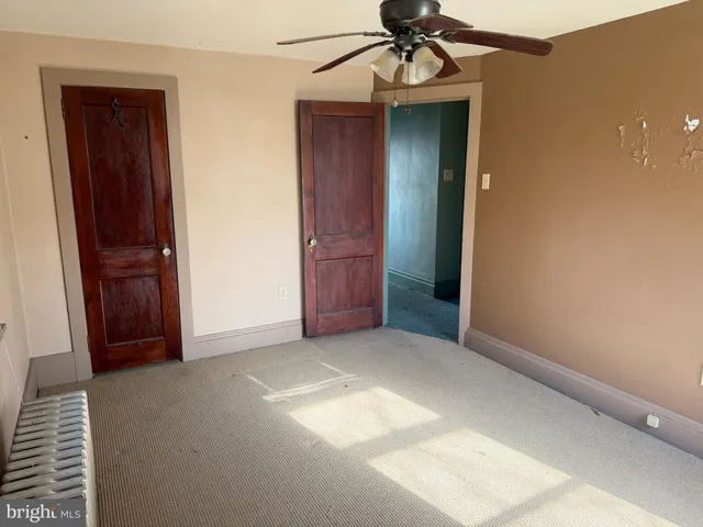 an empty room with closet and a chandelier fan