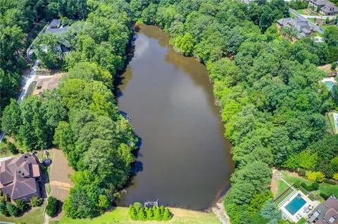 an aerial view of a house with a yard and lake