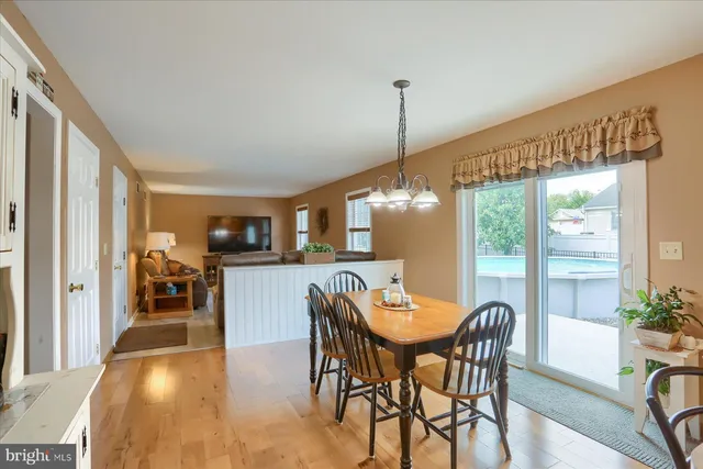 a kitchen with stainless steel appliances kitchen island granite countertop a table and chairs in it