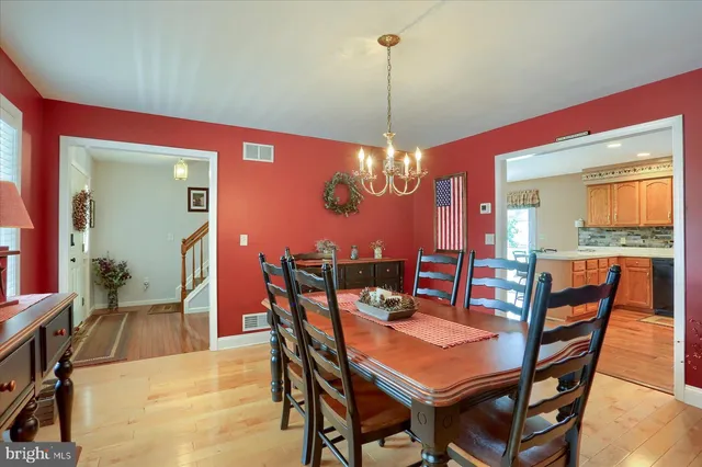 a view of a dining room with furniture a chandelier and wooden floor