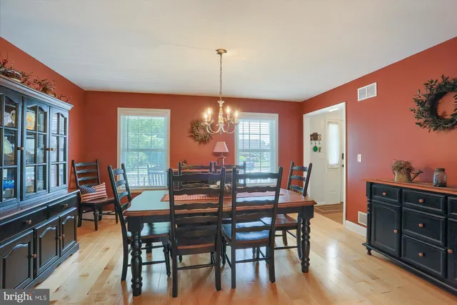 a dining room with furniture window wooden floor and a chandelier