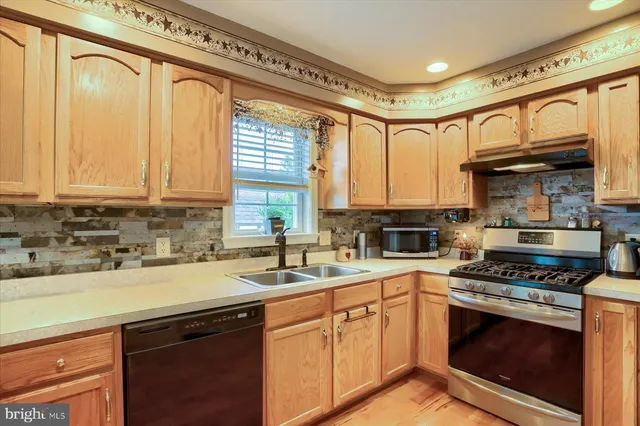 a kitchen with stainless steel appliances a stove a sink and a microwave
