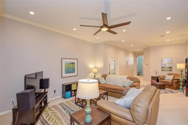 a living room with furniture a ceiling fan and a rug