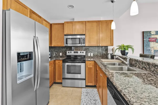 a kitchen with stainless steel appliances granite countertop a sink stove and refrigerator