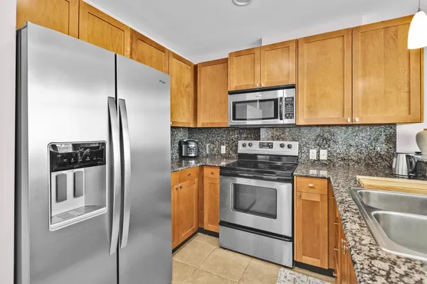 a kitchen with stainless steel appliances granite countertop a stove a refrigerator and a sink