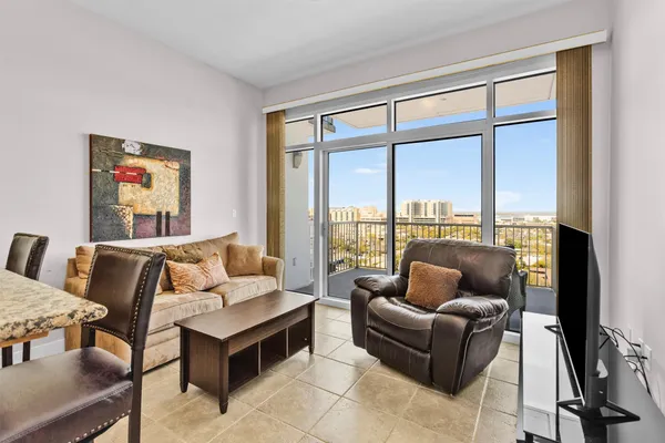 a living room with furniture and a floor to ceiling window