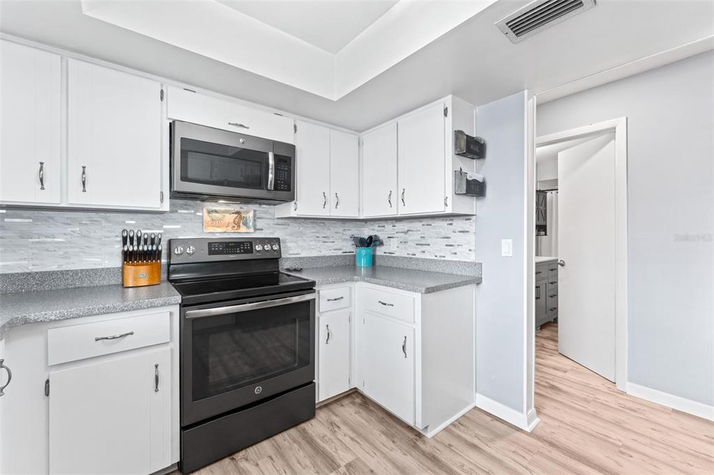 29 Pelican Lane Edgewater, FL 32141 - Photo 10 of 39 a kitchen with cabinets stainless steel appliances and wooden floor
