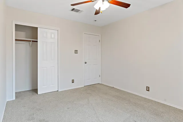 an empty room with chandelier fan