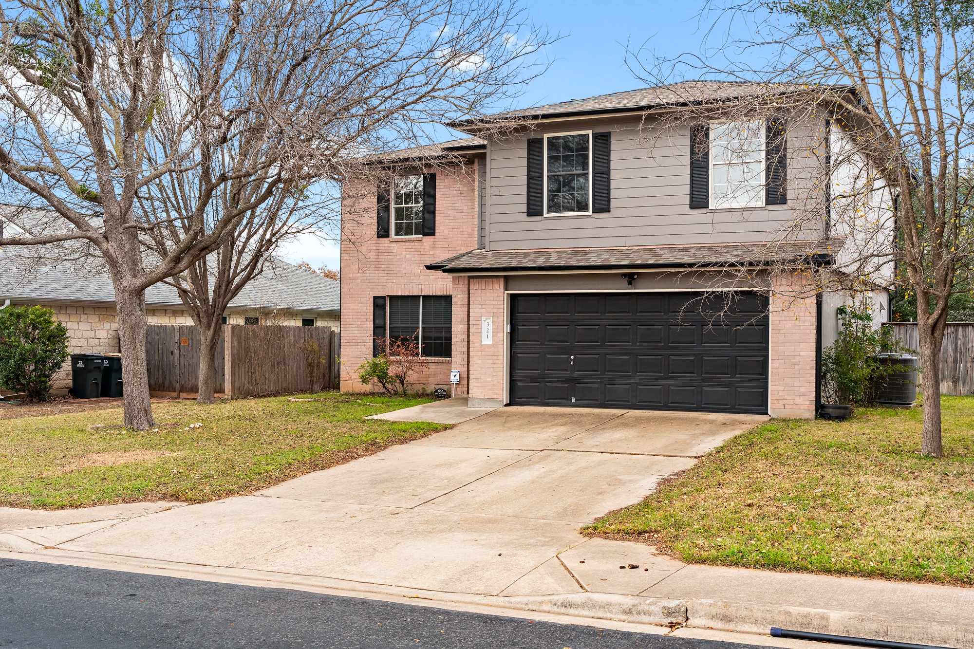 321 Nicole Way Bastrop, TX 78602 - Photo 2 of 32 Traditional home featuring an attached garage, driveway, and brick siding