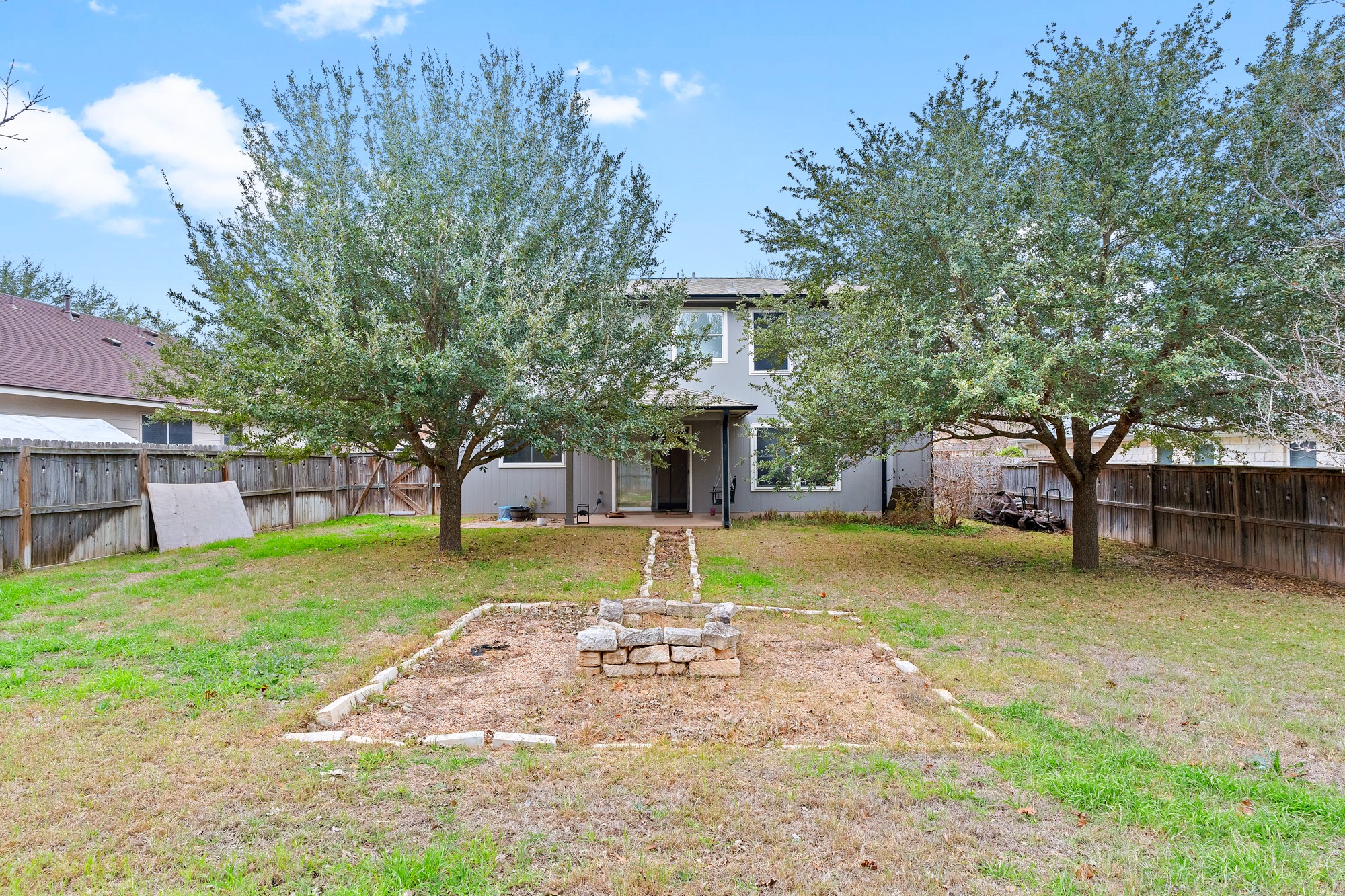 321 Nicole Way Bastrop, TX 78602 - Photo 29 of 32 Rear view of property featuring a fenced backyard and an outdoor fire pit