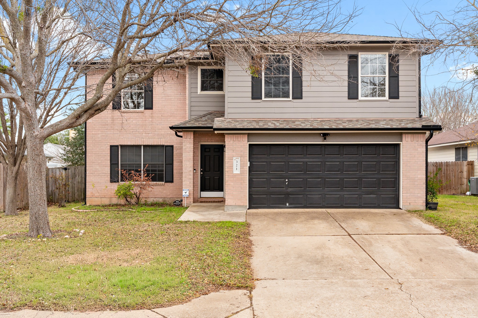 321 Nicole Way Bastrop, TX 78602 - Photo 3 of 32 Traditional home with an attached garage, driveway, and brick siding