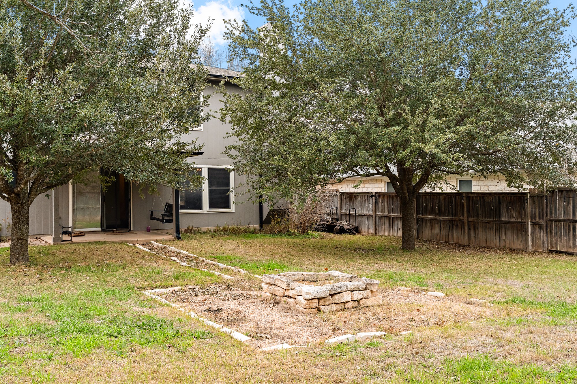 321 Nicole Way Bastrop, TX 78602 - Photo 31 of 32 Fenced yard featuring an outdoor fire pit and a patio