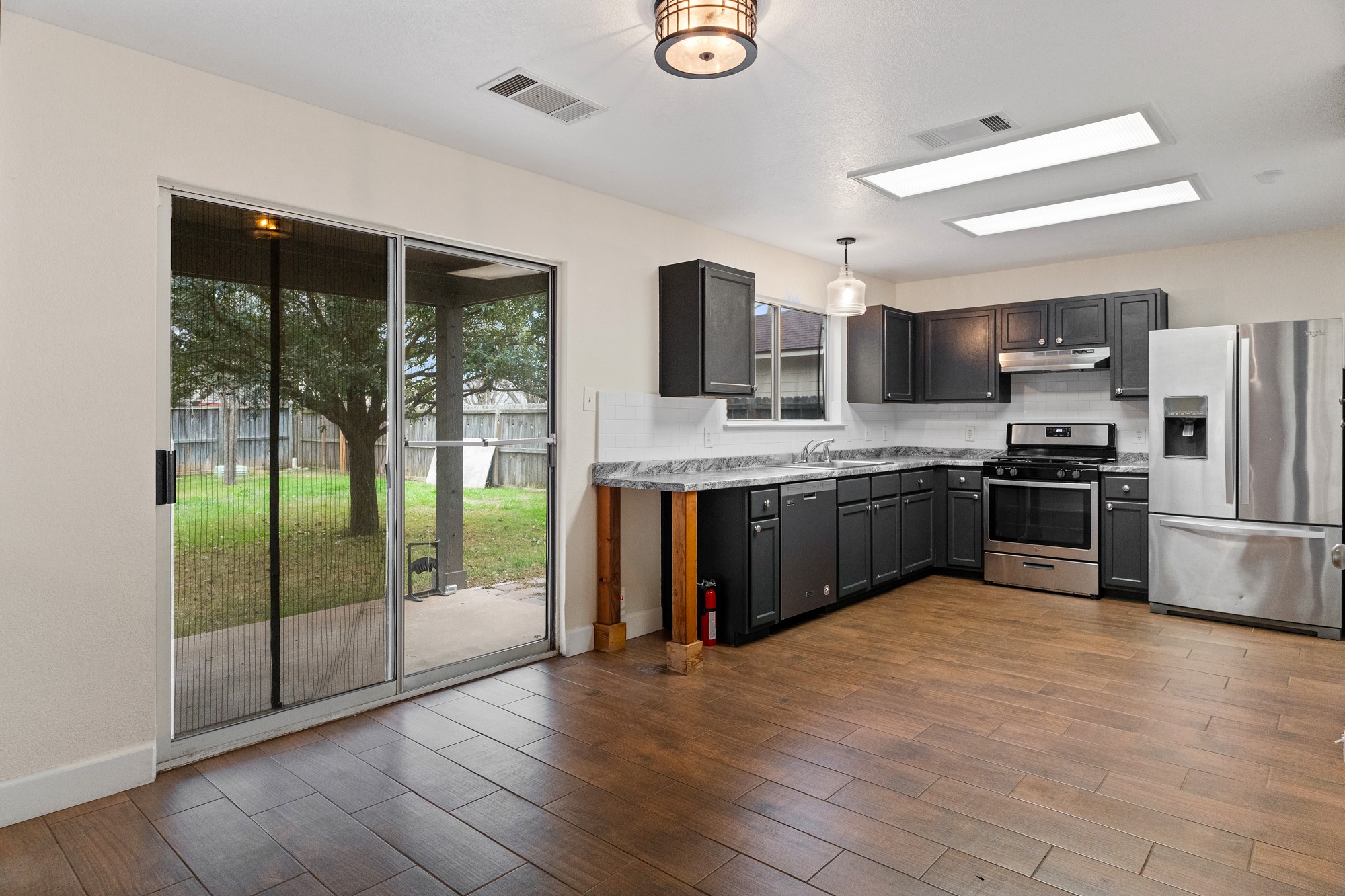 321 Nicole Way Bastrop, TX 78602 - Photo 9 of 32 Kitchen with stainless steel appliances, light countertops, dark wood finished floors, and pendant lighting