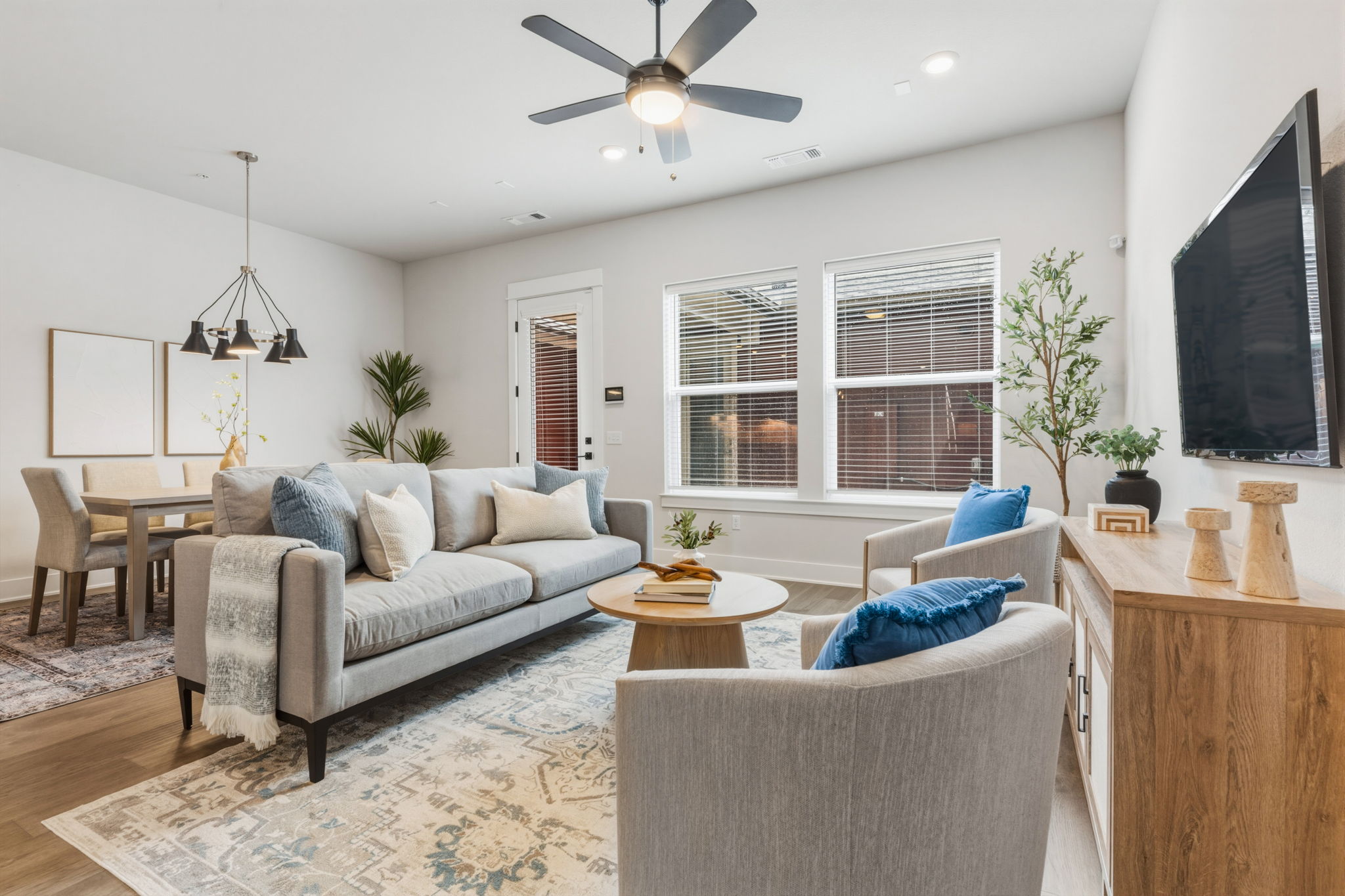 2929 Moreno Street Austin, TX 78723 - Photo 20 of 40 Open-concept living area featuring wood-finish flooring, a contemporary ceiling fan, and multiple windows with blinds