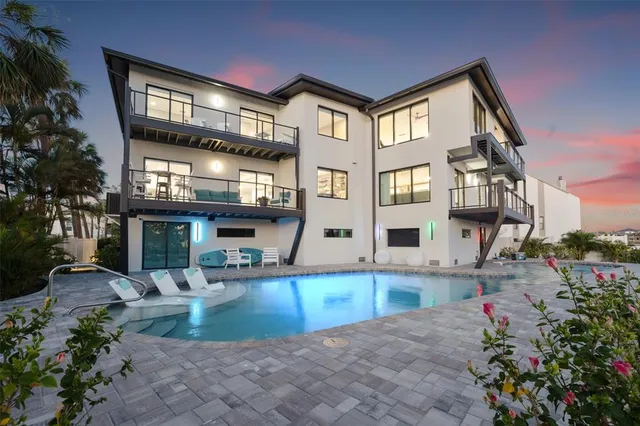 a kitchen with stainless steel appliances kitchen island granite countertop a dining table chairs and sink