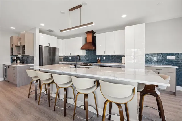 a kitchen with stainless steel appliances granite countertop a oven and a view of living room