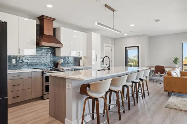 a kitchen with stainless steel appliances granite countertop a refrigerator a stove and a sink