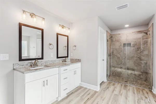 a bathroom with a double vanity sink mirror and shower
