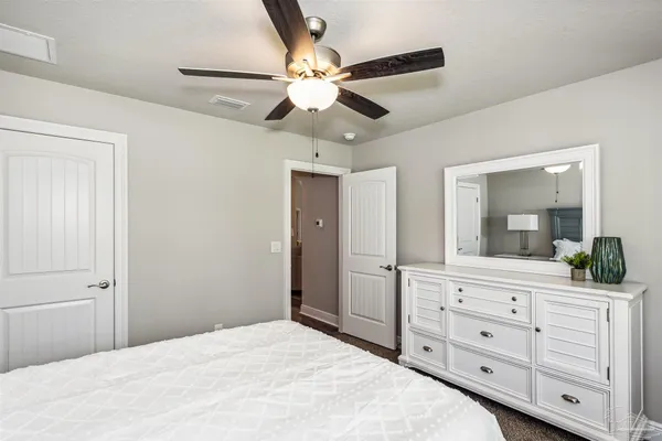a bedroom with a large bed and a chandelier