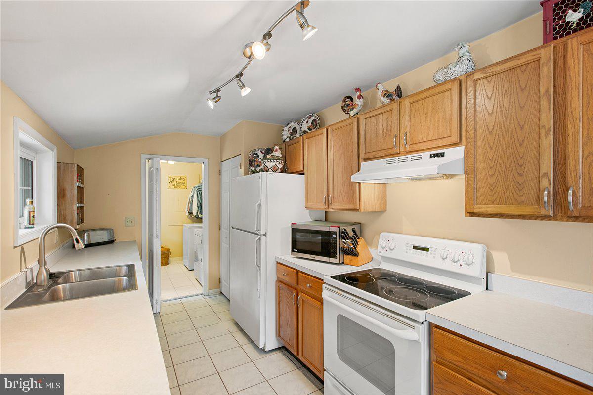 19266 Mockingbird Heights Road Triangle, VA 22172 - Photo 12 of 35 a kitchen with a refrigerator a stove top oven and cabinets