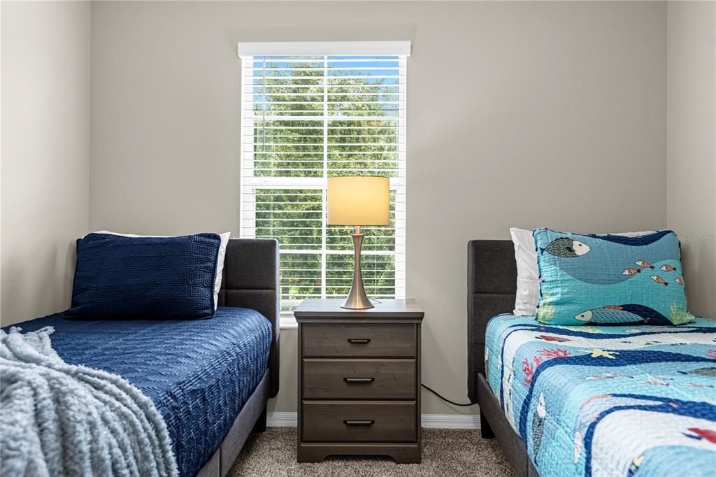 8558 Crystal Cove Loop Kissimmee, FL 34747 - Photo 26 of 35 a bedroom with a bed and a dresser next to a window