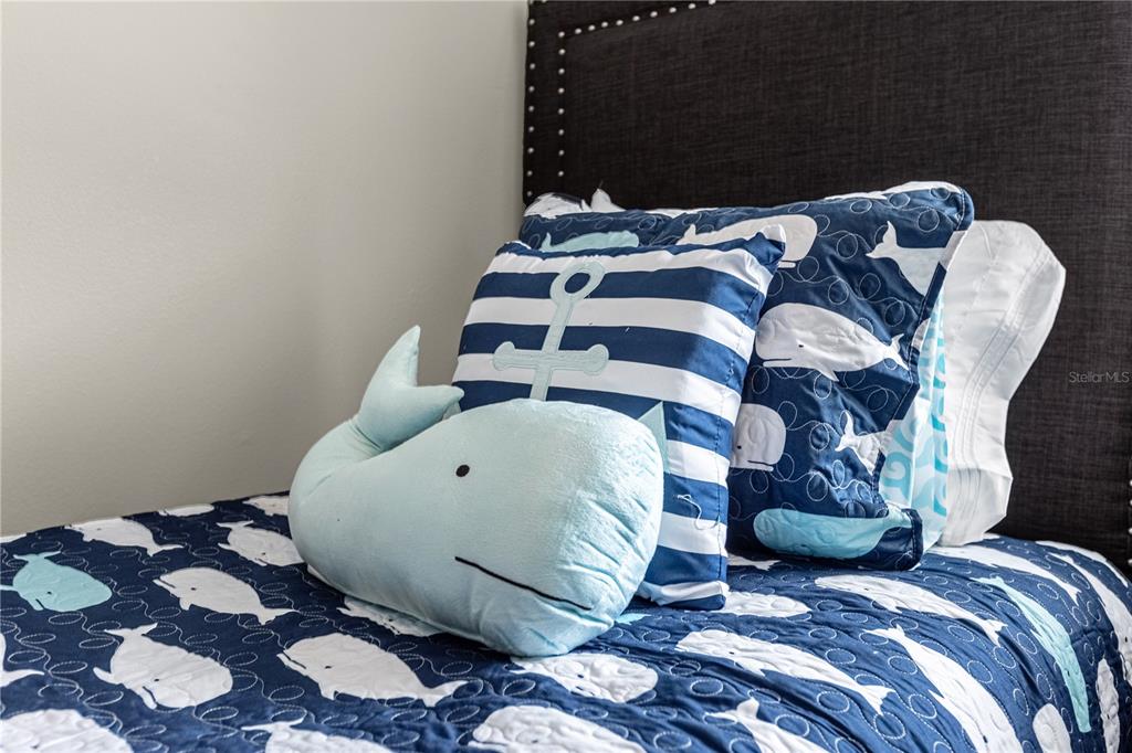 8558 Crystal Cove Loop Kissimmee, FL 34747 - Photo 29 of 35 a large bed sitting in a bedroom next to a window and a mirror