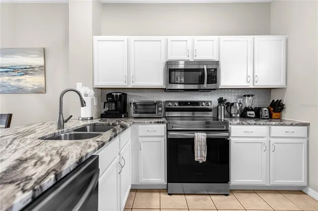 a kitchen with stainless steel appliances granite countertop a sink stove and microwave