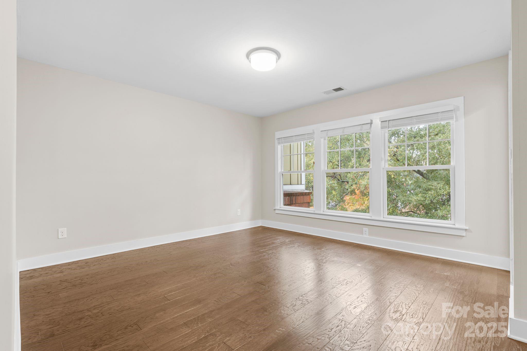 129 Grandin Road Charlotte, NC 28208 - Photo 23 of 35 an empty room with wooden floor and windows