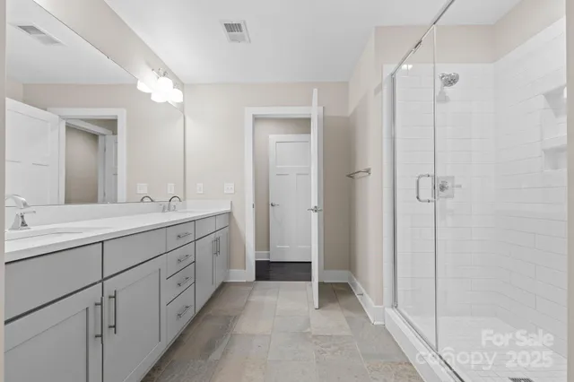a spacious bathroom with a shower sink and mirror