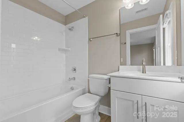 a bathroom with a sink toilet vanity and shower