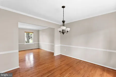 a view of empty room with wooden floor and window