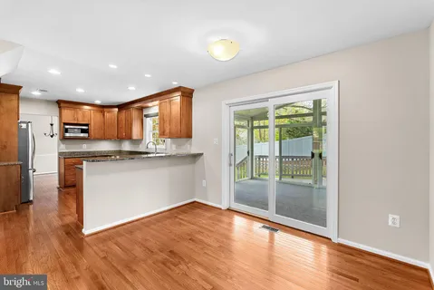 a kitchen with stainless steel appliances granite countertop a refrigerator a stove a sink and a large window