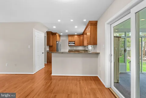 a view of kitchen with kitchen island wooden floor window and refrigerator