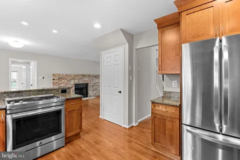 a kitchen with a refrigerator stove and wooden cabinets