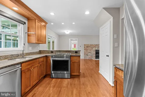 a large kitchen with stainless steel appliances granite countertop a stove and a sink