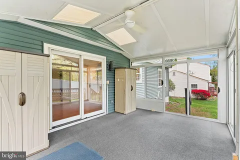 a view of an empty room with wooden floor and windows