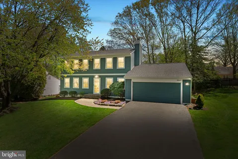 a front view of a house with a yard and trees