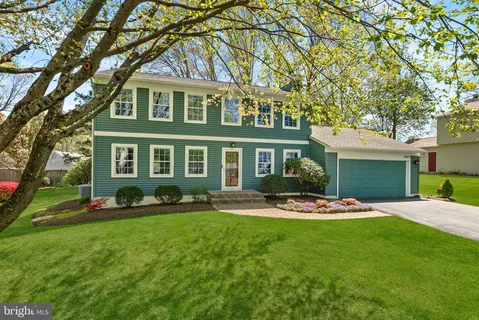 a front view of a house with a yard and trees