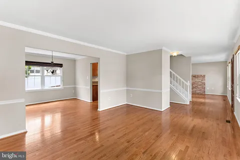 a view of empty room with wooden floor and window