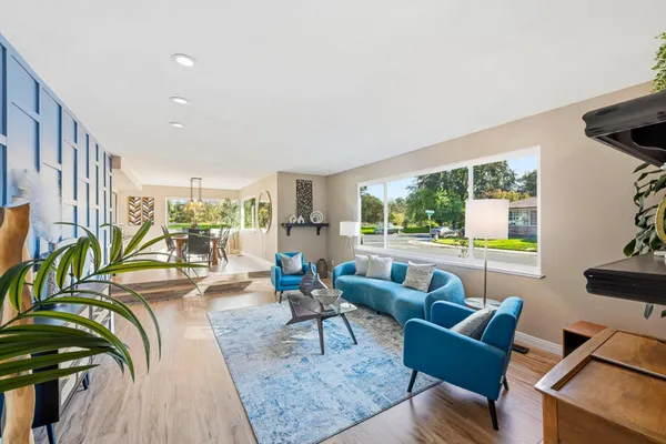 a living room with furniture and a floor to ceiling window