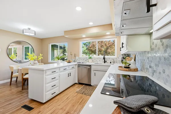 a kitchen with stainless steel appliances granite countertop a sink a stove and cabinets