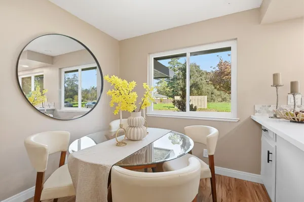 a kitchen with granite countertop white cabinets and wooden floor